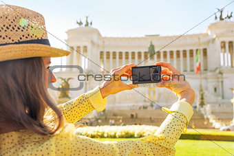 Closeup on young woman taking photo on piazza venezia in rome, i