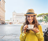 Portrait of happy young woman with cup of coffee on piazza venez