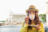 Young woman drinking coffee on piazza venezia in rome, italy