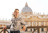 Portrait of happy young woman in front of basilica di san pietro