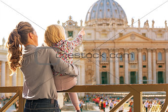 Mother and baby girl pointing on basilica di san pietro in vatic