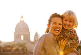 Portrait of happy mother and baby girl against rome panorama on 