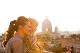 Mother and baby girl looking on rome panorama on sunset
