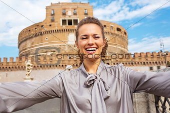 Happy young woman making selfie in front of castel sant\'angelo i