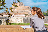 Young woman with map on embankment near castel sant'angelo in ro