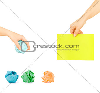 crumpled paper in a female hand and a piece of paper in a female