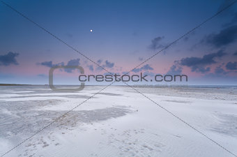 full moon and sunrise sky over sand beach
