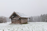 old wooden hut at snowstorm
