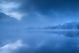 lake in Alps during misty morning