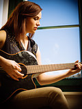 Young woman playing acoustic guitar