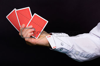 man's hand holding three cards and the ace in the hole