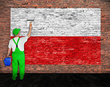 House painter paints flag of Poland on brick wall