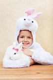Cute little girl in bunny costume with white rabbit