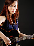 Young beautiful woman playing acoustic guitar