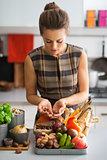 Young housewife with vegetables in kitchen