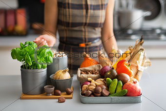 Closeup on young housewife with vegetables in kitchen