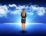 Businesswoman standing against blue landscape with rising sun