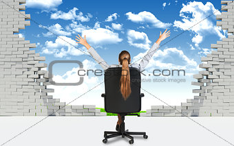 Businesswoman sitting on the office chair in front of broken wall