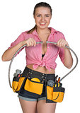 Woman in tool belt holding flexible tap hose