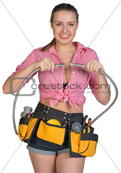 Woman in tool belt holding flexible tap hose