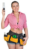 Woman in tool belt holding energy-saving lamp