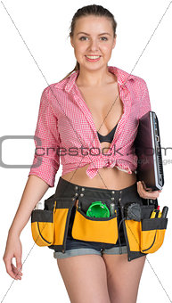 Woman in tool belt, holding laptop under her armpit