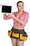Woman in tool belt showing tablet PC with blank screen