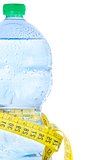 half plastic bottle with water, drops and measuring tape, concept of fitness and diet