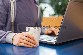 Young student using his laptop in cafe