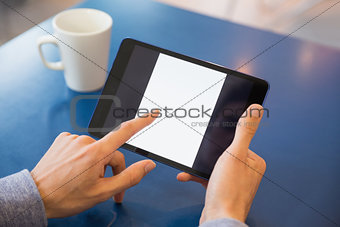 Young student using his tablet in cafe