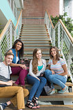 Smiling students sitting on steps