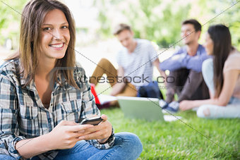 Happy students sitting outside on campus