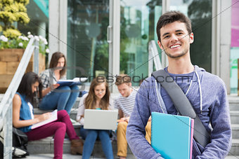 Handsome student smiling at camera outside