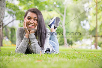 Pretty brunette smiling at camera in park