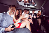 Happy friends drinking champagne in limousine