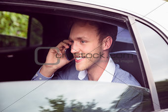 Young man talking on phone in limousine