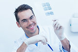 Smiling male dentist holding at x-ray