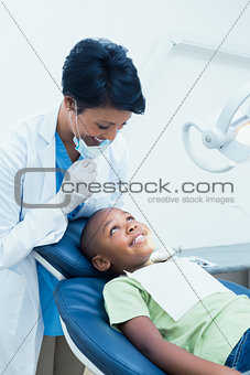 Portrait of smiling female dentist examining boys teeth