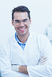 Happy male dentist with arms crossed
