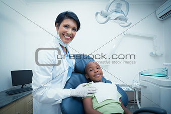 Portrait of smiling female dentist examining boys teeth