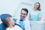 Dentist examining girls teeth with assistant