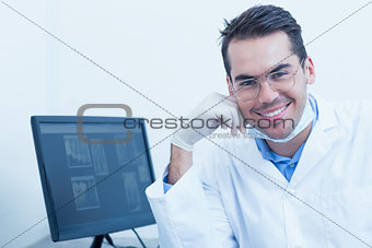 Smiling male dentist with computer