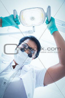 Female dentist adjusting light