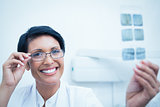 Happy female dentist holding x-ray