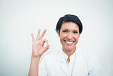 Smiling female dentist gesturing okay sign