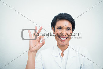 Smiling female dentist gesturing okay sign