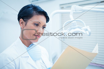Female dentist reading reports