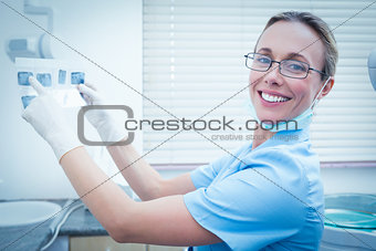 Female dentist holding x-ray