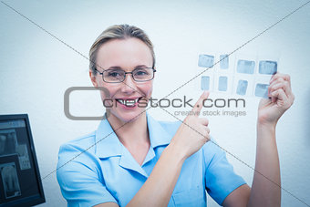 Smiling female dentist pointing at x-ray