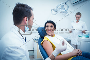 Dentist and assistant with smiling female patient